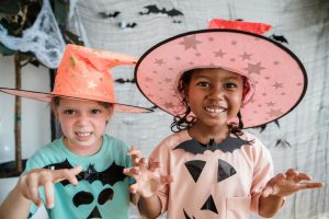 Two children in Halloween fancy dress playfully snarling at the camera.